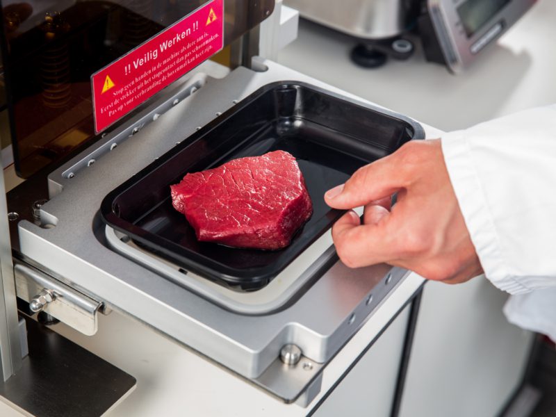 Slager die vers vlees verpakt middels machine